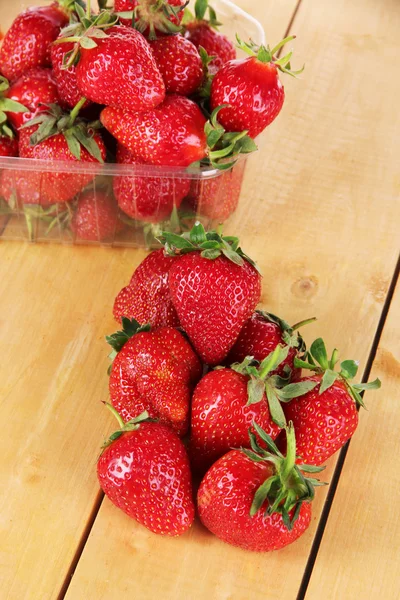Många jordgubbar på träbord — Stockfoto