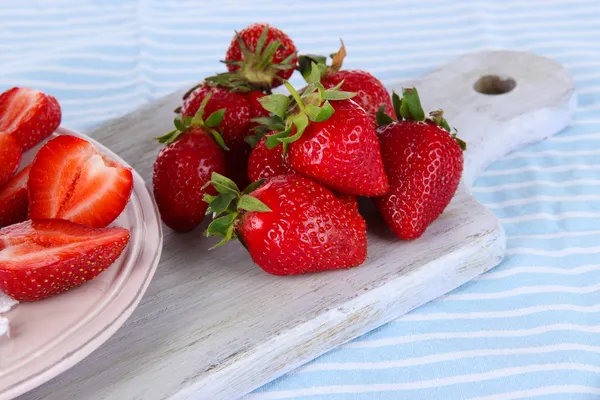 Erdbeeren an Bord schneiden auf gestreifter Serviette — Stockfoto