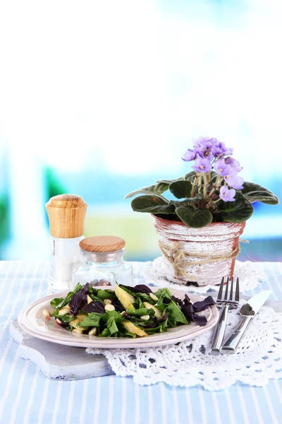 Light salad on plate on table on room background