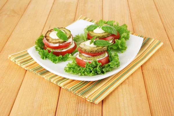 Tasty moelle rôtie et tranches de tomate avec des feuilles de salade, sur fond de bois — Photo