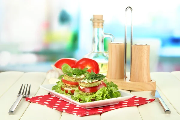 Tasty roasted marrow and tomato slices with salad leaves, on bright background — Stock Photo, Image