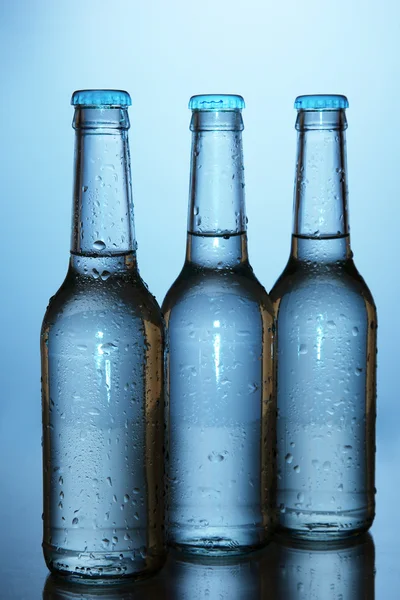 Бутылки с водой на голубом фоне — стоковое фото