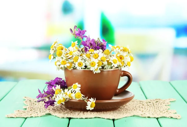 Strauß von Kamillenblüten in Tasse, auf hellem Hintergrund — Stockfoto