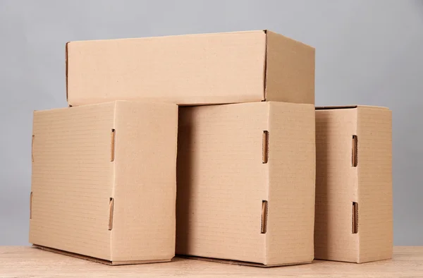 Cajas de paquetes sobre mesa de madera, sobre fondo gris — Foto de Stock