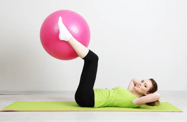 Porträtt av vacker ung kvinna övningar med gym boll — Stockfoto