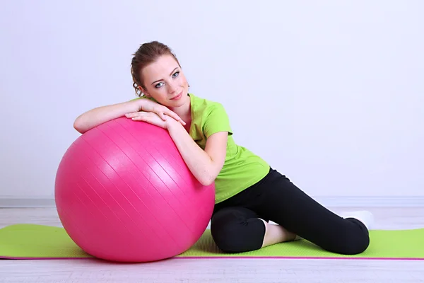 Portret van mooie jonge vrouw oefeningen met gymnastiek bal — Stockfoto