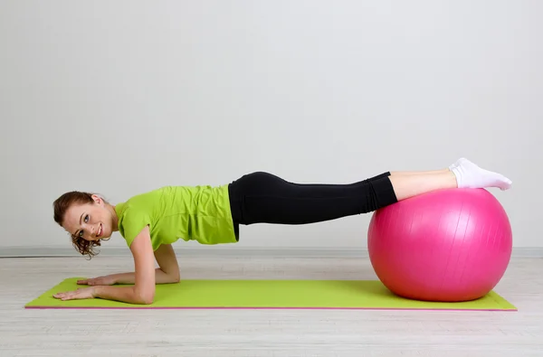 Porträtt av vacker ung kvinna övningar med gym boll — Stockfoto