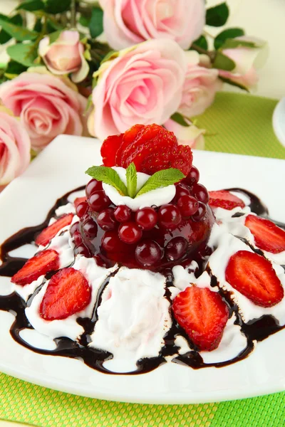 Sabroso postre de gelatina con bayas frescas, sobre fondo de rosas rosadas —  Fotos de Stock