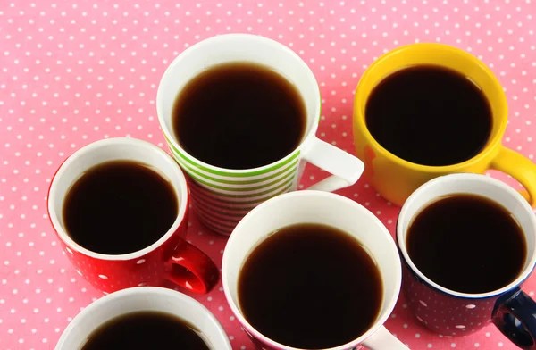 Molte tazze di caffè su tovagliolo rosa — Foto Stock