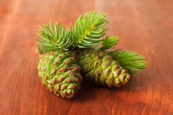 Cones verdes e abeto em fundo de madeira — Fotografia de Stock