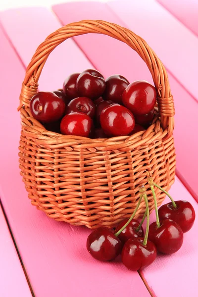 Kirschbeeren im Weidenkorb auf Holztisch in Großaufnahme — Stockfoto