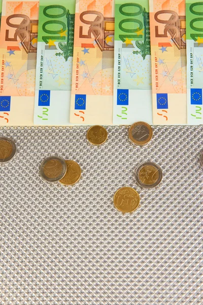 Банкноты евро и центы евро на сером фоне — стоковое фото