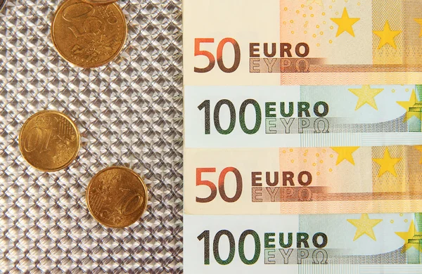 Eurobankbiljetten en eurocent op grijze achtergrond — Stockfoto