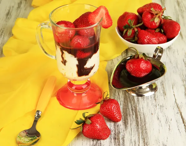 Вкусный клубничный десерт в стеклянной вазе на деревянном столе крупным планом — стоковое фото