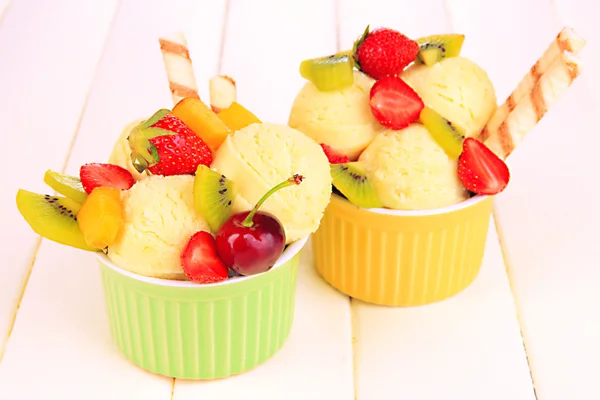 Délicieuse crème glacée aux fruits et baies dans un bol sur une table en bois — Photo