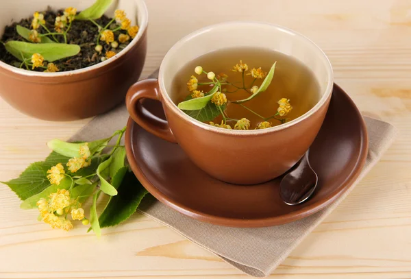 Xícara de chá com tília em guardanapo mesa de madeira — Fotografia de Stock