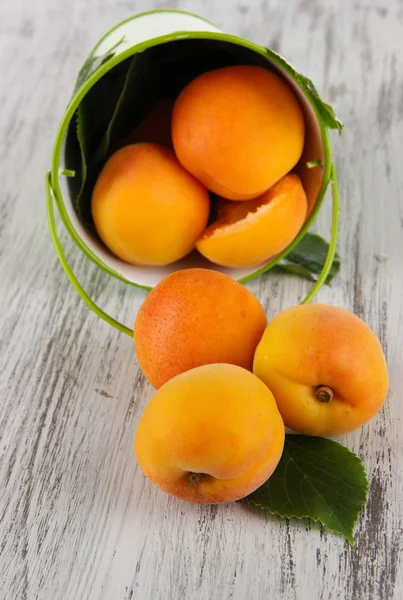 Apricots in bucket on wooden table — Stock Photo, Image