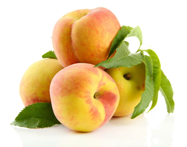 Reife süße Pfirsiche mit Blättern, isoliert auf weiß — Stockfoto