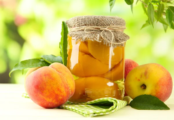 Jar 的罐头桃子和新鲜桃子木桌子上外 — 图库照片