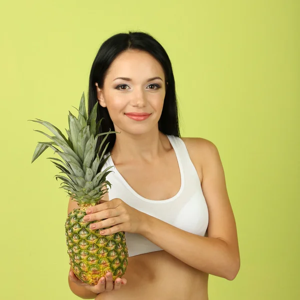 Mädchen mit frischer Ananas auf grünem Hintergrund — Stockfoto