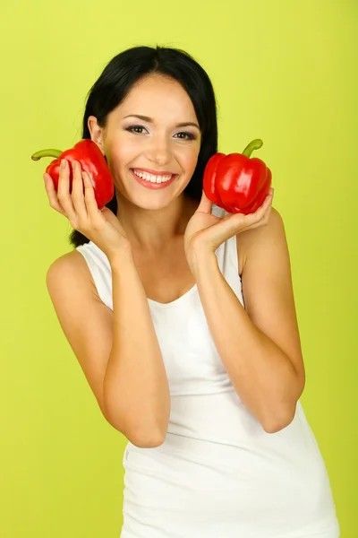 Girl with fresh peppers on green background — Stock Photo, Image