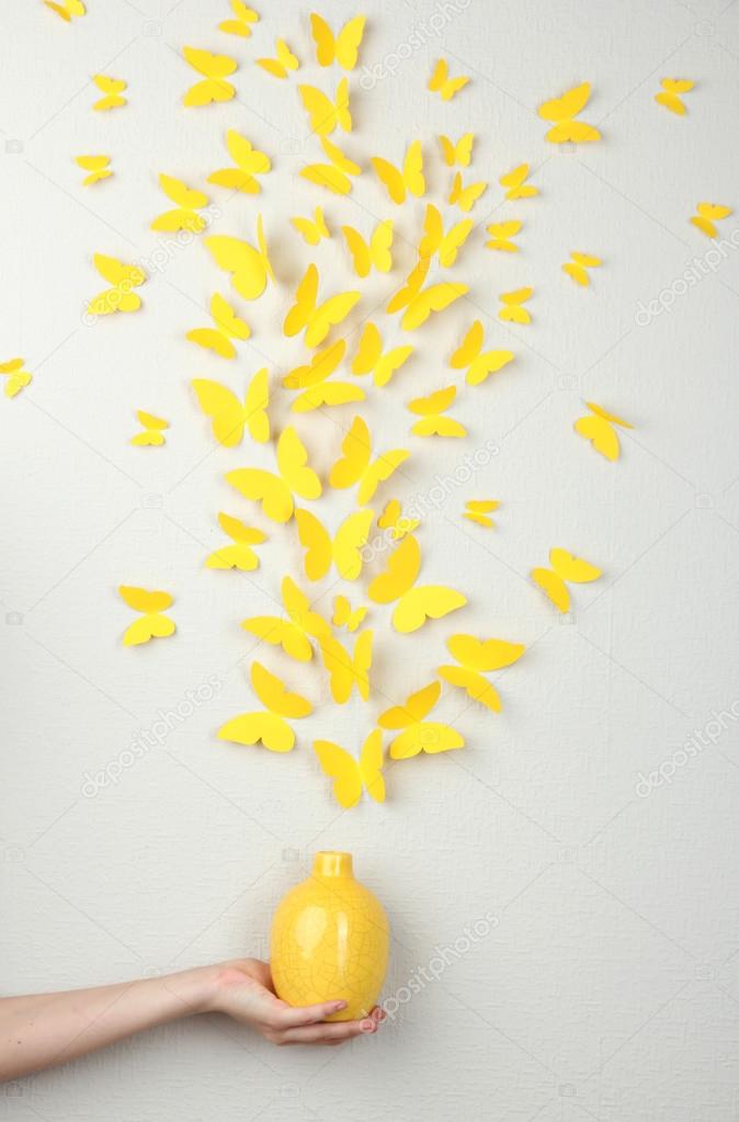 Paper yellow butterflies fly out of vase