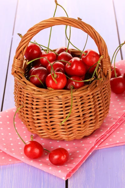 Wiśnia jagody w wiklinowym koszu na drewnianym stole z bliska — Zdjęcie stockowe