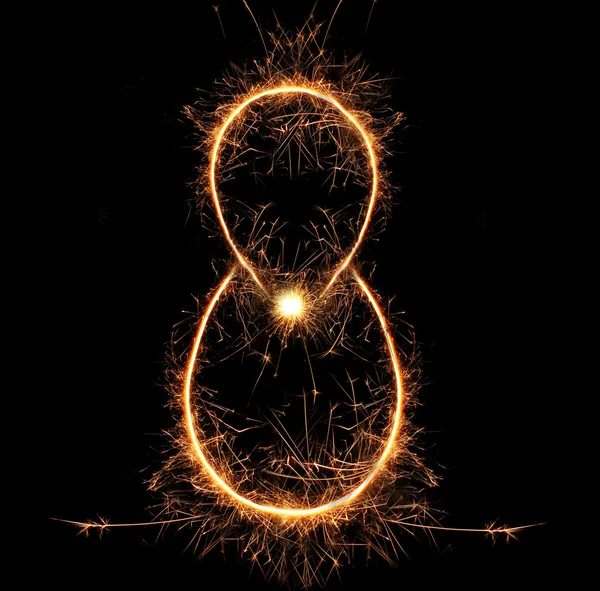 Number "eight" sparklers on black background — Stock Photo, Image