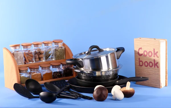 Composition of kitchen tools,spices and cook book on blue background — Stock Photo, Image