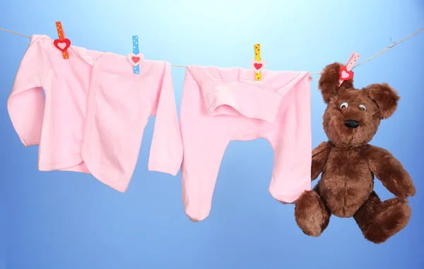 婴儿衣服挂在晾衣绳上颜色背景 — 图库照片