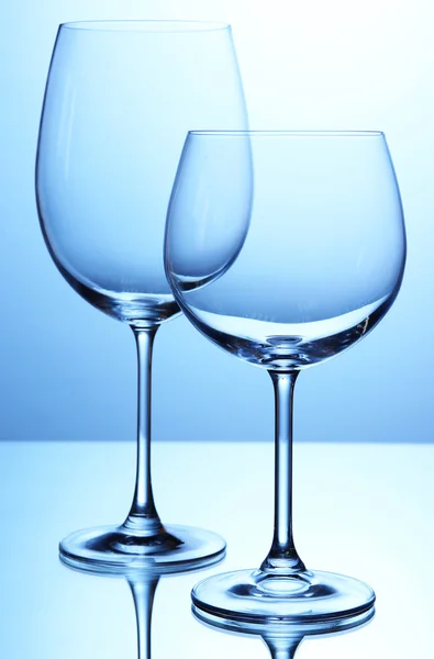 แก้วไวน์เปล่าจัดเรียงบนพื้นหลังสีฟ้า — ภาพถ่ายสต็อก