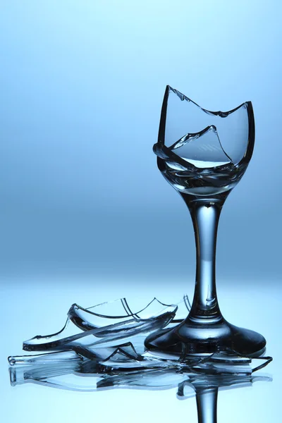 Broken wineglass on blue background — Stock Photo, Image