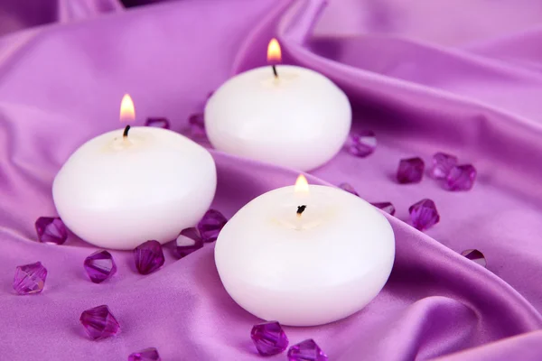 Candles on purple fabric close-up — Stock Photo, Image