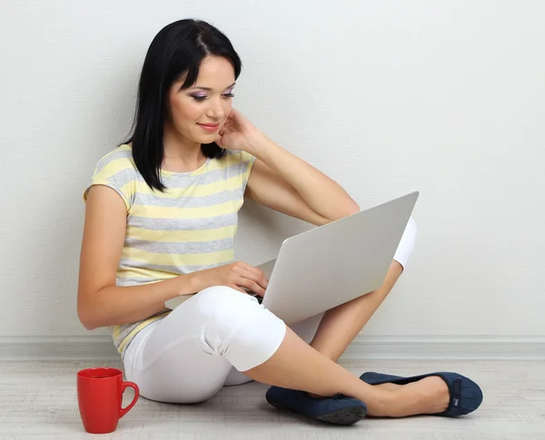 Hermosa joven sentada con cuaderno en la habitación —  Fotos de Stock