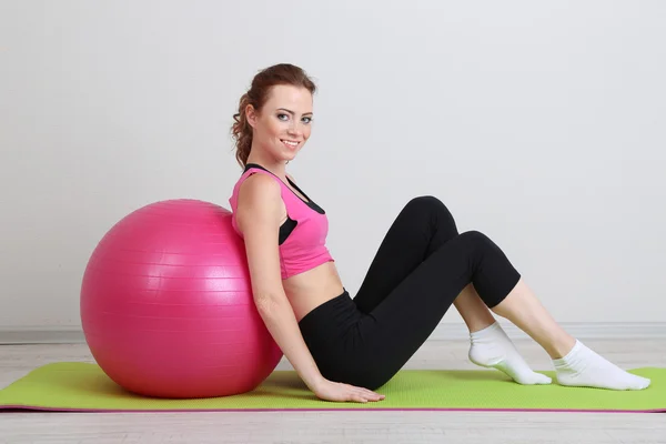 Porträtt av vacker ung kvinna övningar med gym boll — Stockfoto