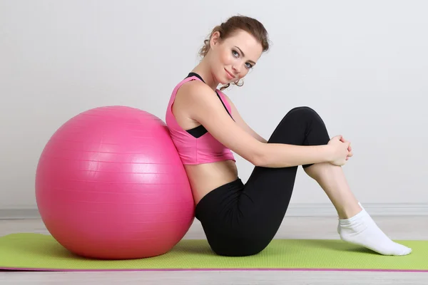 Portret van mooie jonge vrouw oefeningen met gymnastiek bal — Stockfoto