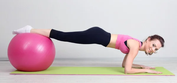 Portret van mooie jonge vrouw oefeningen met gymnastiek bal — Stockfoto