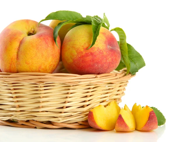 Ripe sweet peaches with leaves in basket, isolated on white — Stock Photo, Image