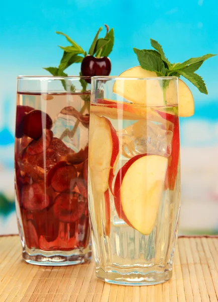 Vasos de bebidas de frutas con hielo sobre fondo azul —  Fotos de Stock