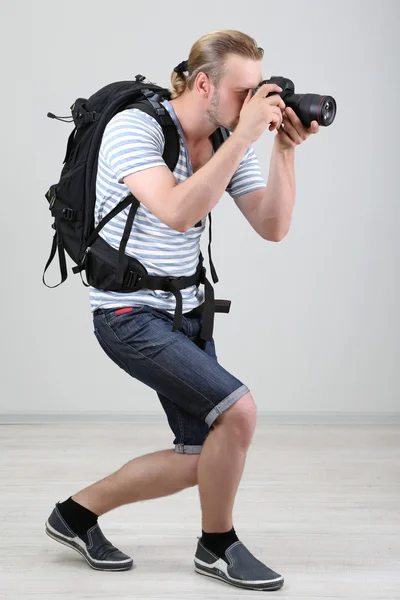 Fotógrafo guapo con cámara, sobre fondo gris —  Fotos de Stock
