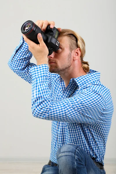 Fotógrafo guapo con cámara, sobre fondo gris —  Fotos de Stock