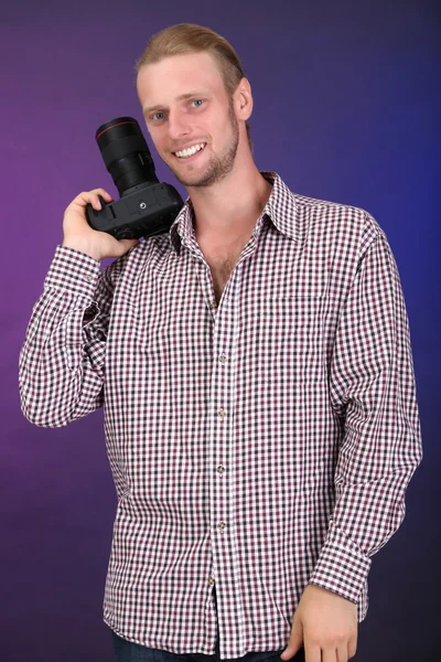 Knappe fotograaf met camera, op donkere kleur achtergrond — Stockfoto