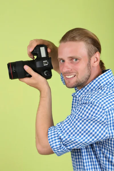 Fotógrafo bonito com câmera, em fundo verde — Fotografia de Stock