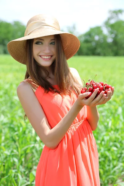 Retrato de una hermosa joven con bayas en el campo — Foto de Stock