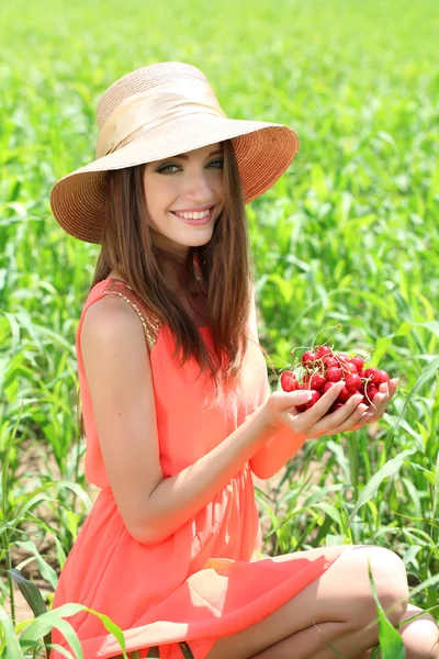 Porträt einer schönen jungen Frau mit Beeren auf dem Feld — Stockfoto