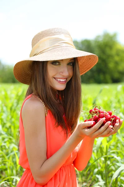 Portrait of beautiful young woman with berries in the field — Stock Photo, Image