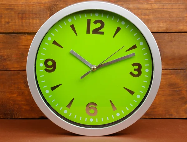 Round office clock on wooden background — Stock Photo, Image