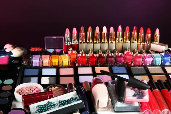 Veel verschillende cosmetica op paarse achtergrond — Stockfoto