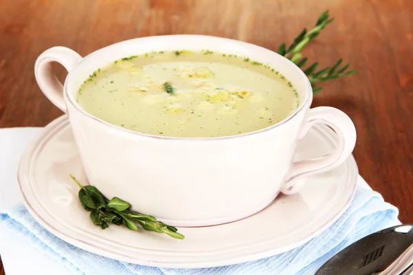 Nourishing soup in pink pan on wooden table close-up — Stock Photo, Image