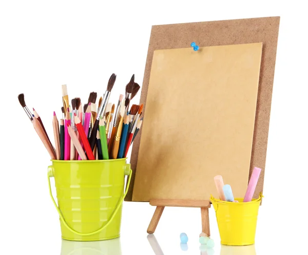 Small easel with sheet of paper with art supplies isolated on white — Zdjęcie stockowe